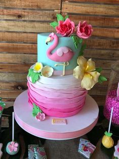 a colorful cake with pink, blue and white frosting sitting on top of a table