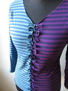 a purple and blue striped top with ruffles on the front, sitting on a mannequin