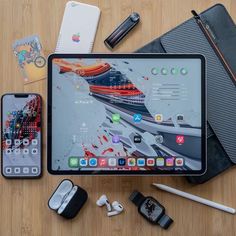 an ipad, cell phone, and other electronics on a table with pens and pencils