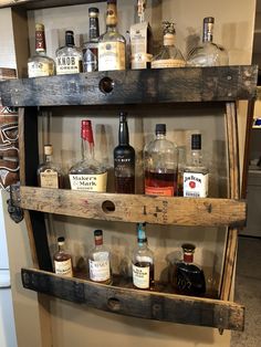 an old wooden shelf filled with liquor bottles