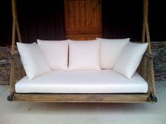 a swing bed with white pillows on it