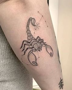 a woman's arm with a scorpion tattoo on the left side of her body