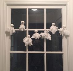 some white paper bats hanging from a window