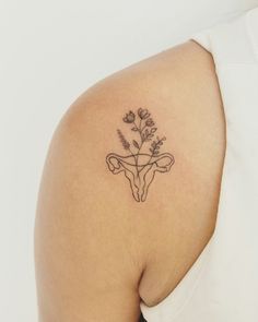 a woman with a tattoo on her shoulder has a cow's head and flowers