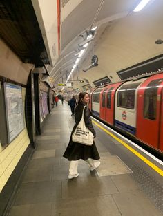 a woman is waiting for the train to arrive