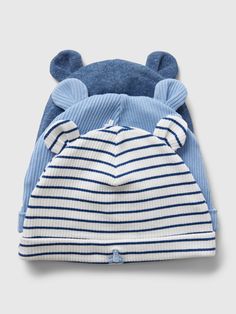 a blue and white striped hat with ears on it's head, sitting next to a