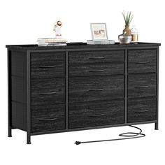 a black dresser with drawers and pictures on it's top shelf, against a white background