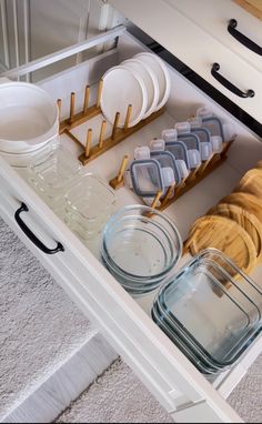 an open drawer filled with dishes and glasses