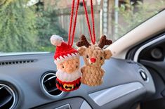 two christmas ornaments hanging from the dashboard of a car