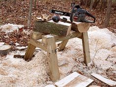 a bench made out of wood with a chainsaw on it in the middle of a forest