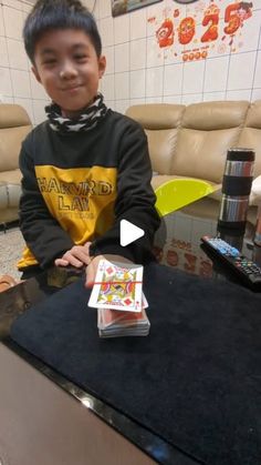 a young boy sitting at a table with pizza boxes in front of him and a yellow frisbee