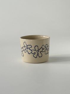 a white and blue flower pot sitting on top of a table