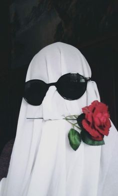 a white ghost with sunglasses and a rose