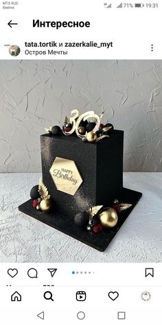 a black and gold birthday cake on a white table with the words happy birthday in russian