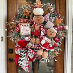 a christmas wreath decorated with teddy bears and candy canes on the front door,