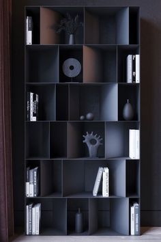 a black shelf with books and vases on it