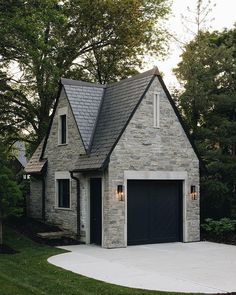 a stone house with a black garage door