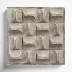 a square wooden wall hanging on the side of a white wall with squares and rectangles