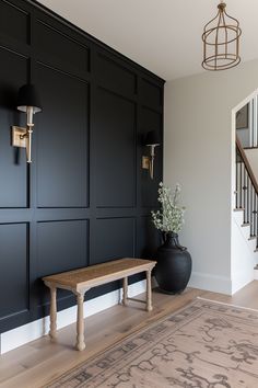 a room with black walls and a wooden bench in the corner next to a stair case