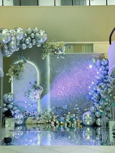 an elaborately decorated display with silver balls and ornaments on the floor in front of a large mirror