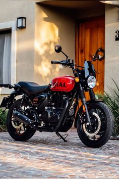 a red and black motorcycle parked in front of a house