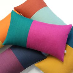 four different colored pillows stacked on top of each other