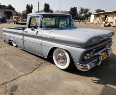 an old gray truck parked in a parking lot