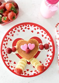 a heart shaped pancake on a plate with strawberries