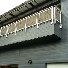 a gray garage with a white railing on it