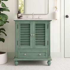 a bathroom with a green cabinet and mirror