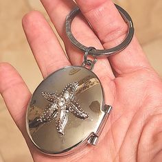 a person holding a key chain with a starfish on it