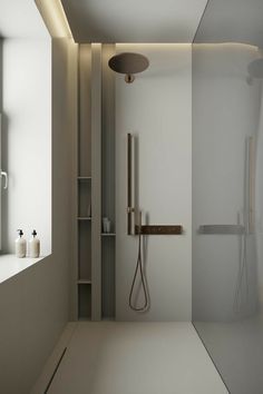 a white bathroom with a shower, sink and mirror in it's corner area