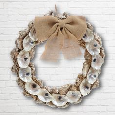 a wreath with seashells hanging on a brick wall