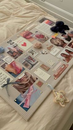 a bed topped with lots of different pictures and writing on top of it next to a teddy bear