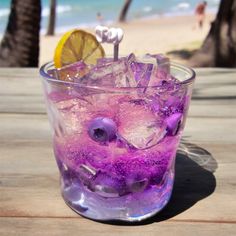 a glass filled with ice and purple liquid