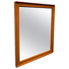 a wooden framed mirror hanging on the wall above it's head and bottom edge