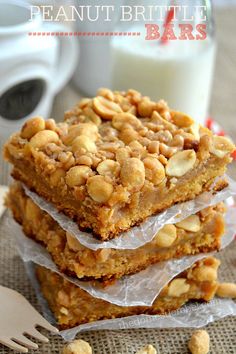 peanut butter brittle bars stacked on top of each other next to a glass of milk