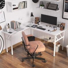 a white desk topped with a computer monitor next to a chair and wall mounted clock