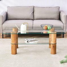 a glass coffee table sitting on top of a carpeted floor next to a couch