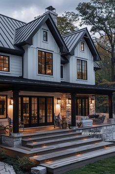 a large white house with stairs leading up to it's front door and windows