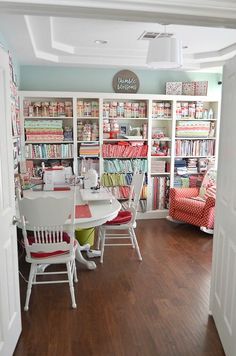 a room with many bookshelves and chairs in it