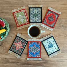 four coasters with different designs on them and a cup of coffee in the middle