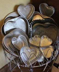 a basket filled with lots of metal heart shaped dishes