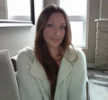 a woman sitting on a couch in front of a window with her arms folded out