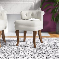 two white chairs sitting on top of a rug