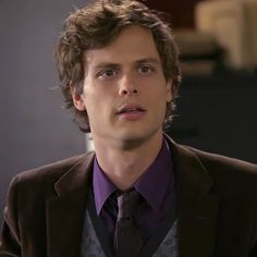 a young man in a suit and tie looking off to the side with serious expression on his face