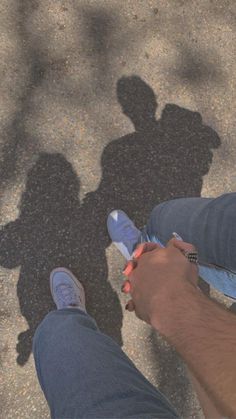 two people standing next to each other with shadows on the ground in front of them