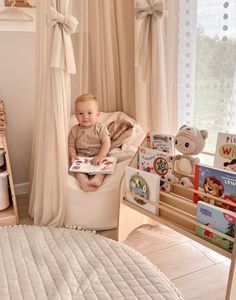 a baby sitting in a chair reading a book