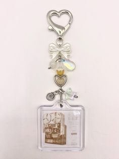 a key chain with charms attached to it on a white surface and a photo hanging from the front