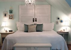 a white bed sitting under a chandelier in a bedroom